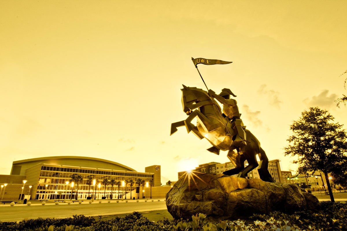 Knight statue with CFE Arena in the background in a golden filter
