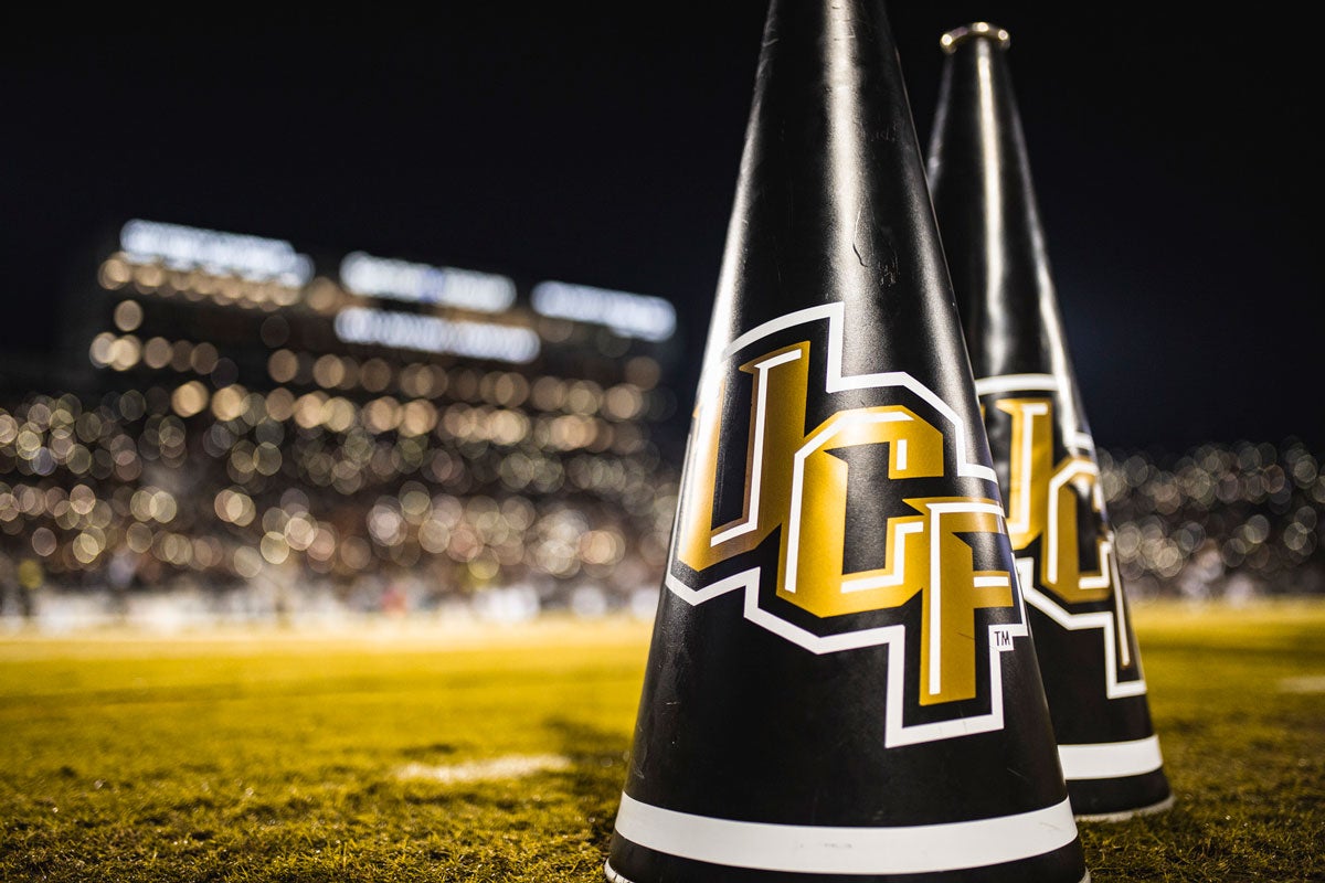 two black megaphones with UCF logo placed on grass in football stadium