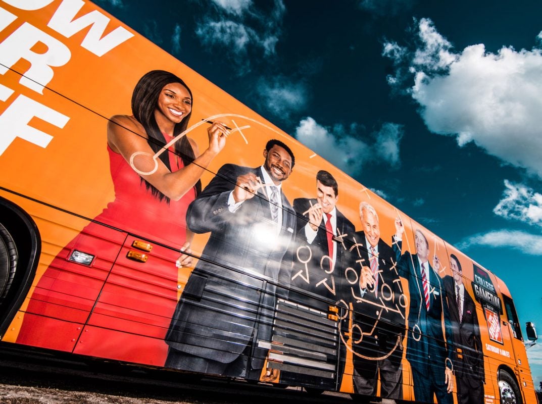 orange bus with cast of College GameDay on the side