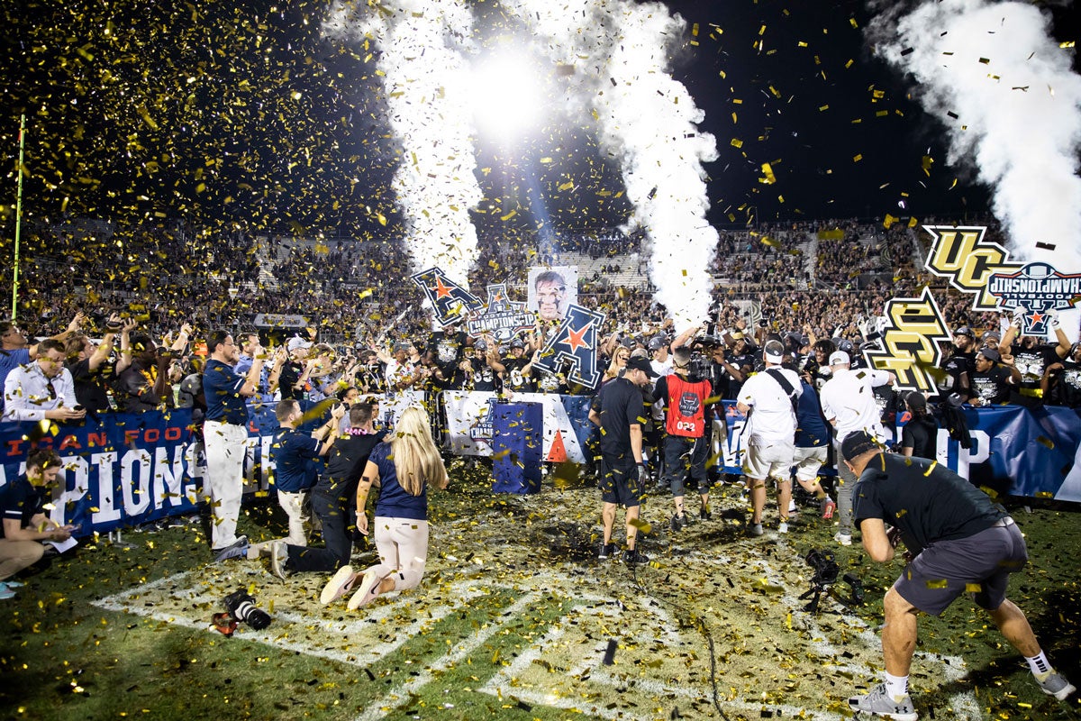 Confetti and smoke fill the air as team celebrates on football field