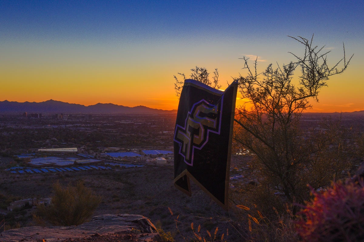 Blue and orange sunset with a UCF flag hanging on a tree