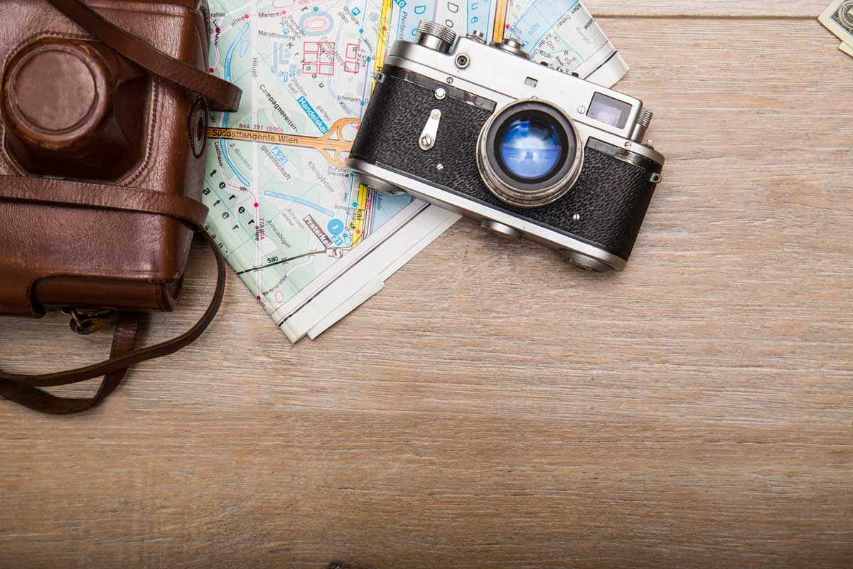 camera and leather camera case rest on top of a folded map