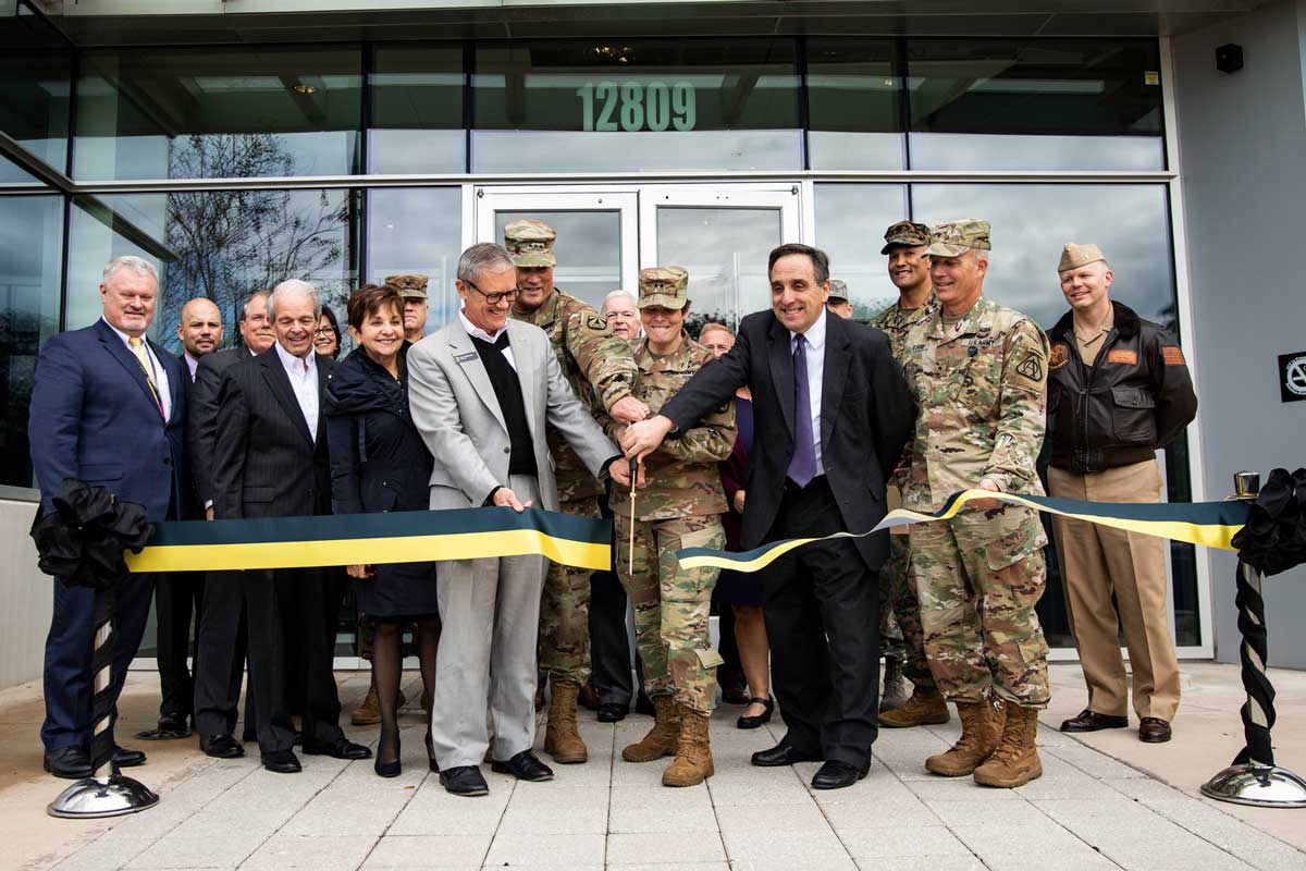 Ribbon cutting ceremony in front of glass building