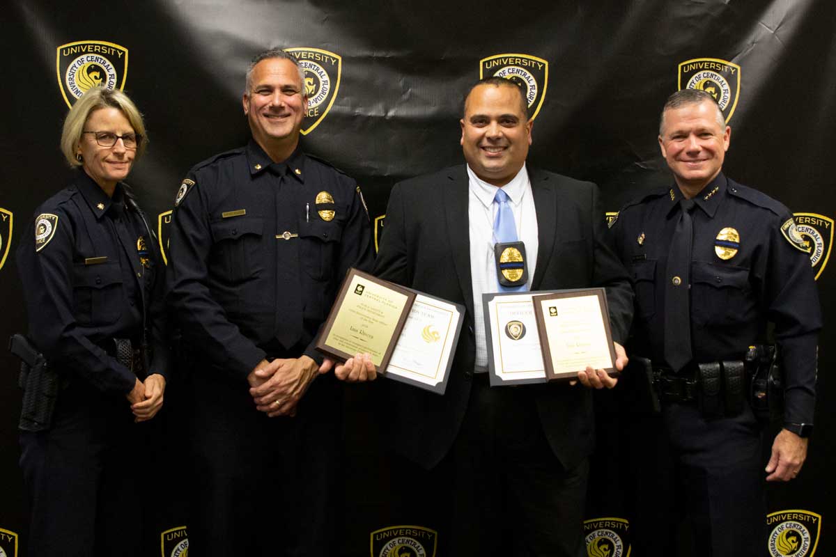 Four officers stand holding awards