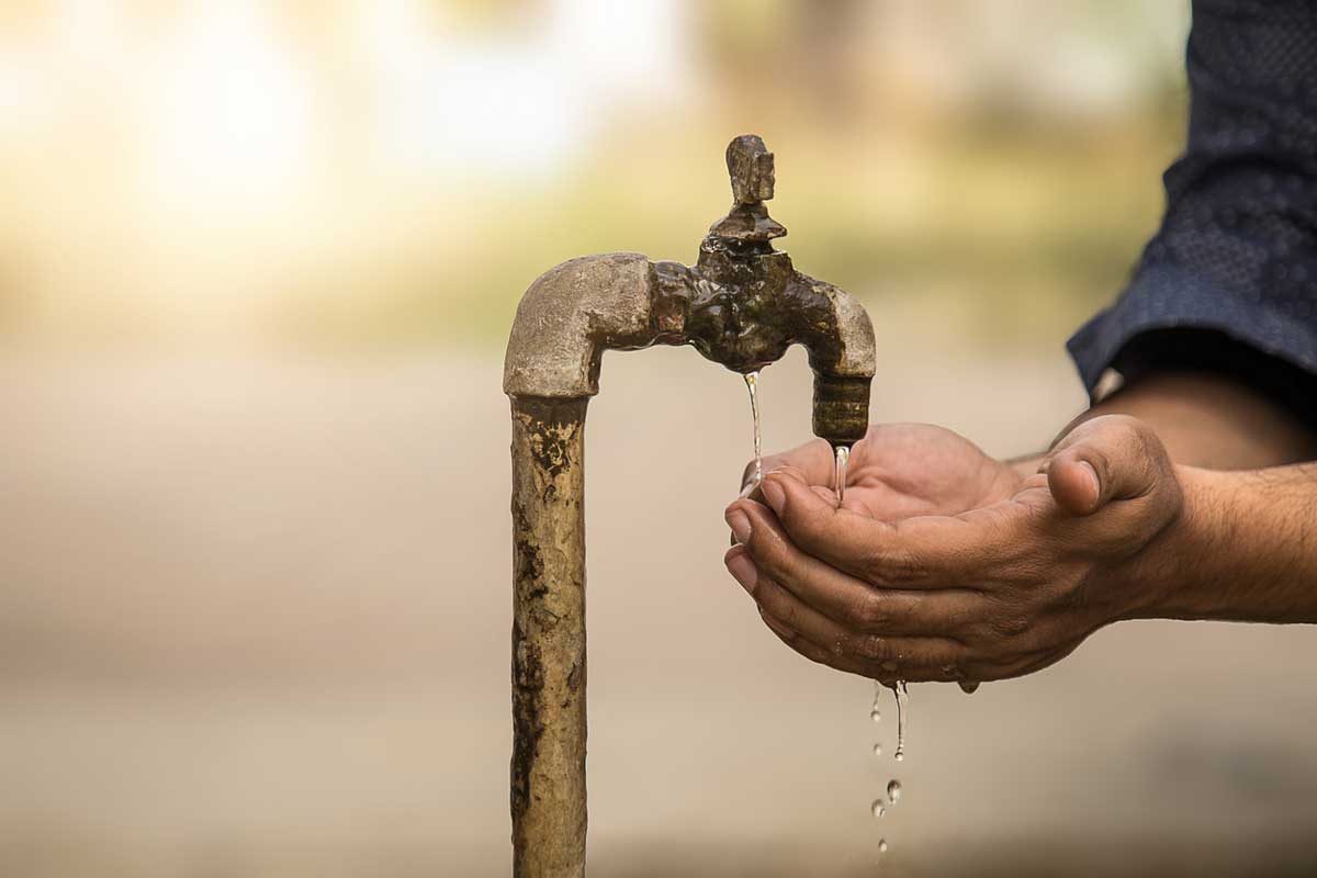 cupped hands under a water spout