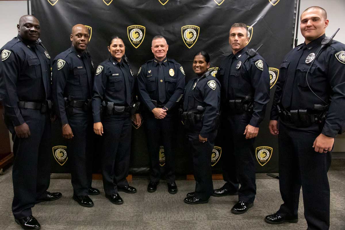 seven uniformed police officers stand shoulder to shoulder