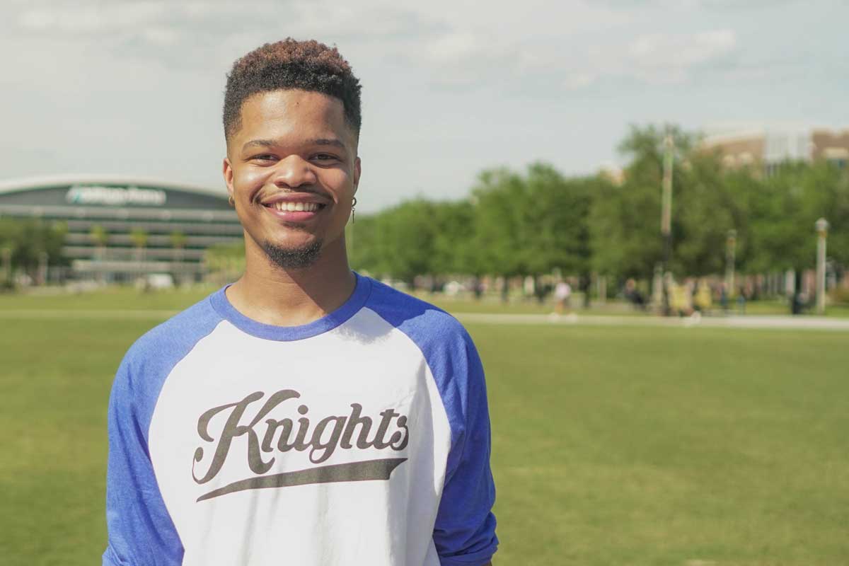 Man wearing Knights T shirt with blue sleeves stands on Memory Mall on sunny day