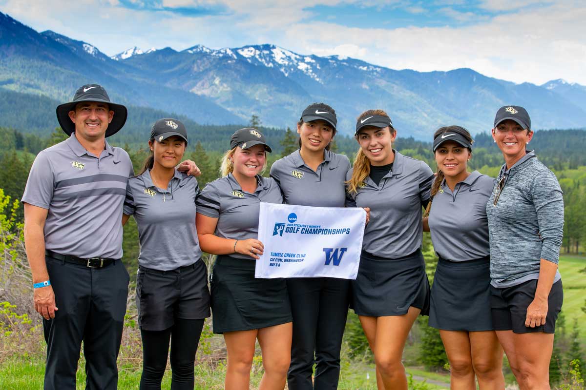 UCF women's golf team poses, arms linked, in front of mountain backdrop