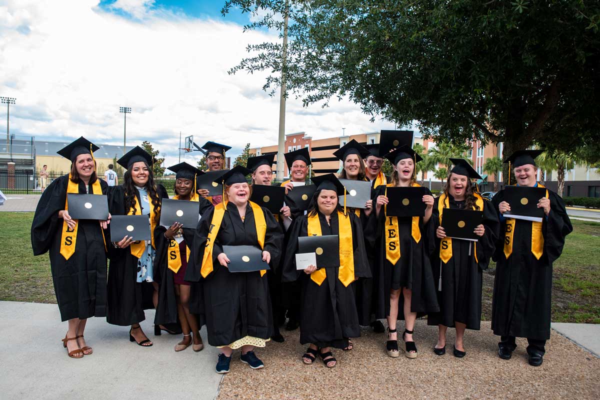 Group of 13 graduates in black cap and gowns