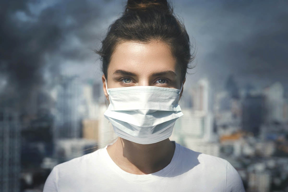 Woman wearing face mask because of air pollution in the city