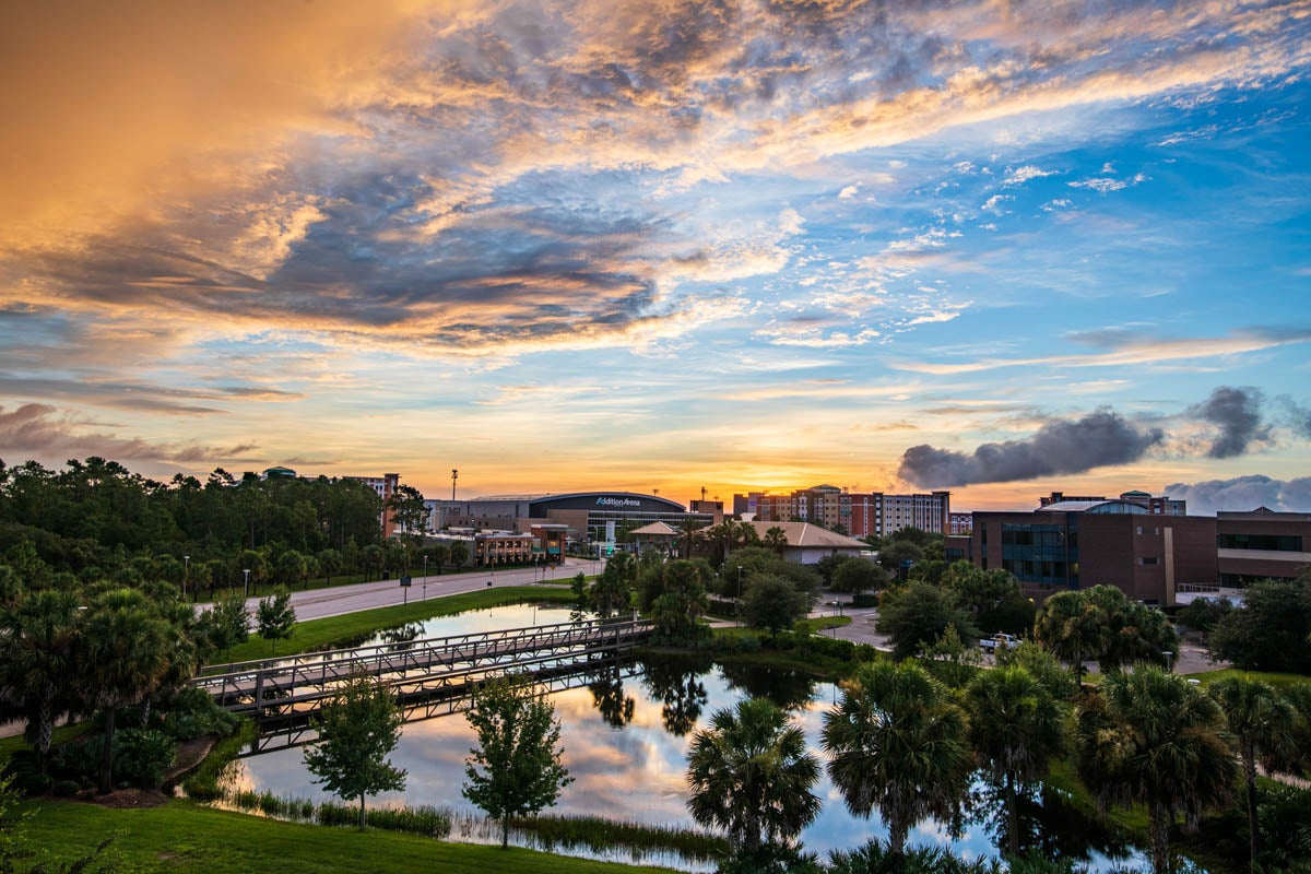 The sun rises above Addition Financial Arena.