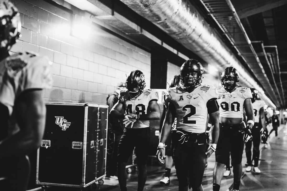 Football players walk through tunnel at stadium