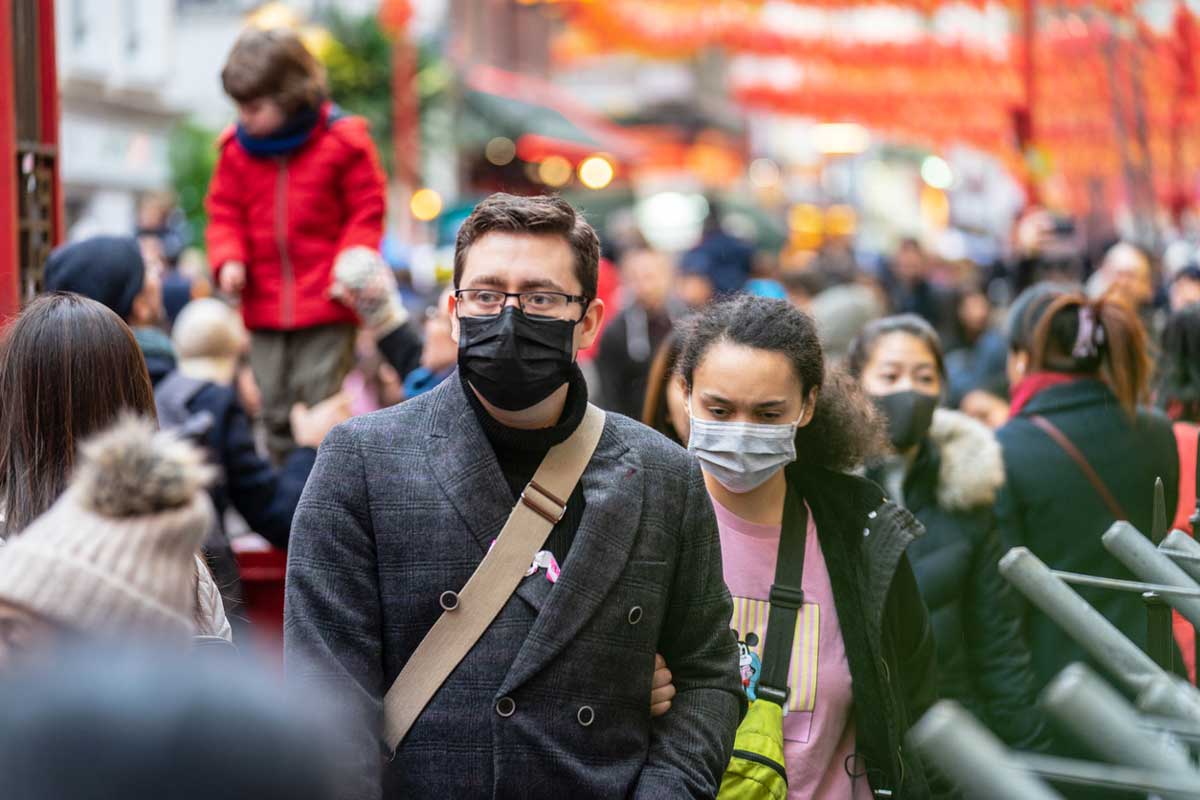 Crowd wearing masks while walking on a street