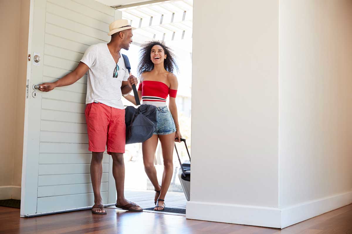 couple arrives in vacation rental with luggage