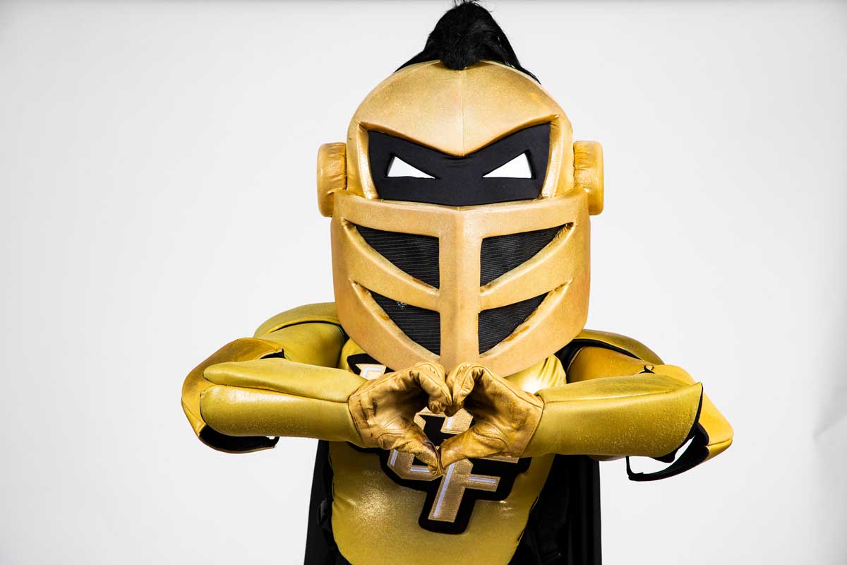UCF mascot Knightro forms heart with his hands