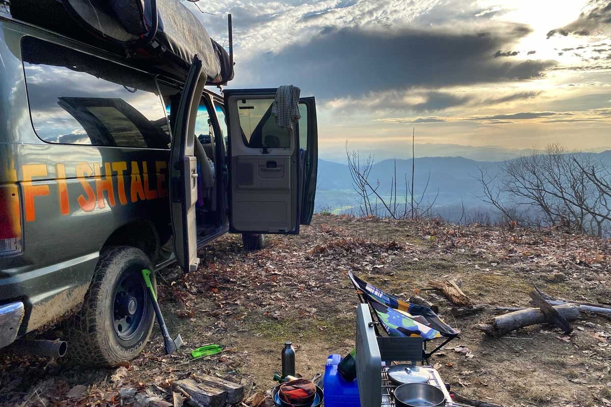 Green van with open doors in wilderness