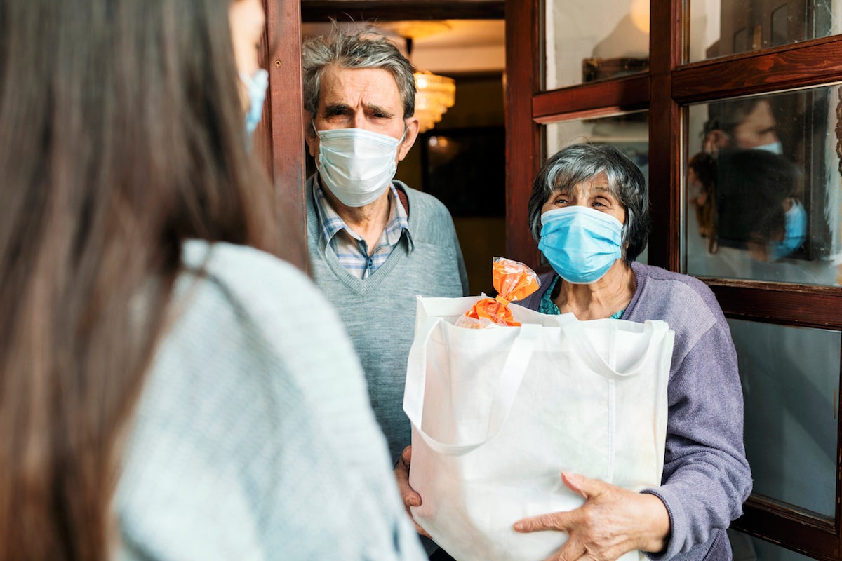 Teenage girl,volunteer,delivering a groceries to a senior couple, insulation,COVID 19.