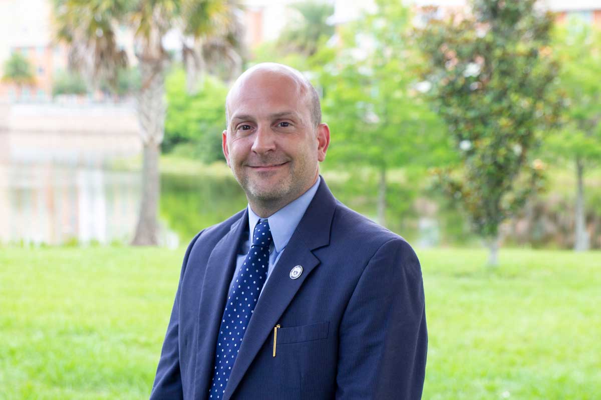 Man wearing blue suit stands outside