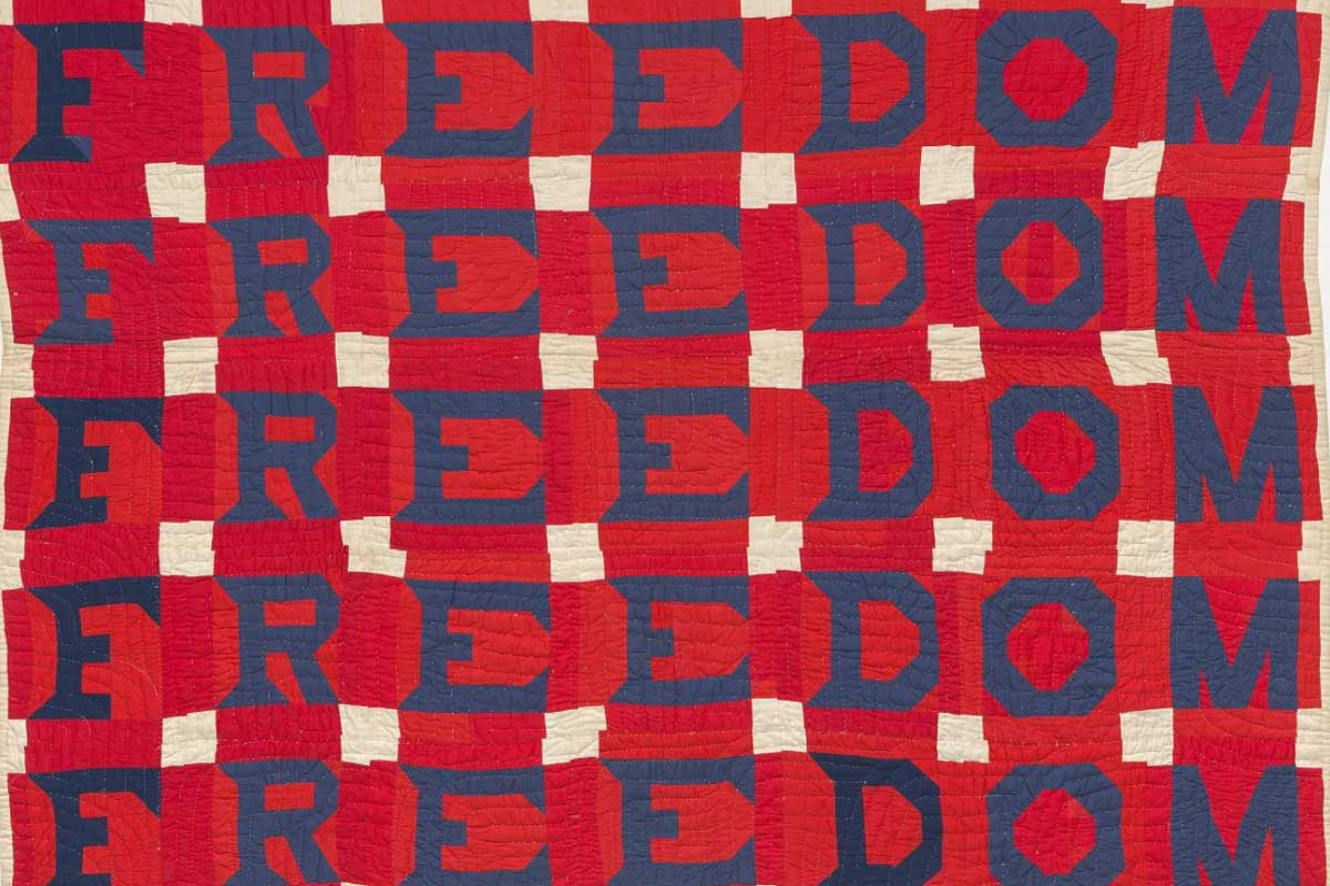 Blue stitched lettering spelling Freedom on red fabric