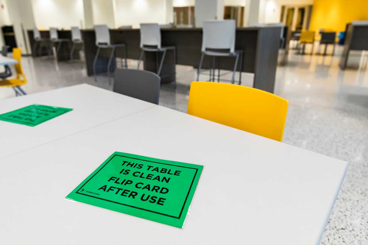 table with green card that reads "this table is clean. flip card after use"