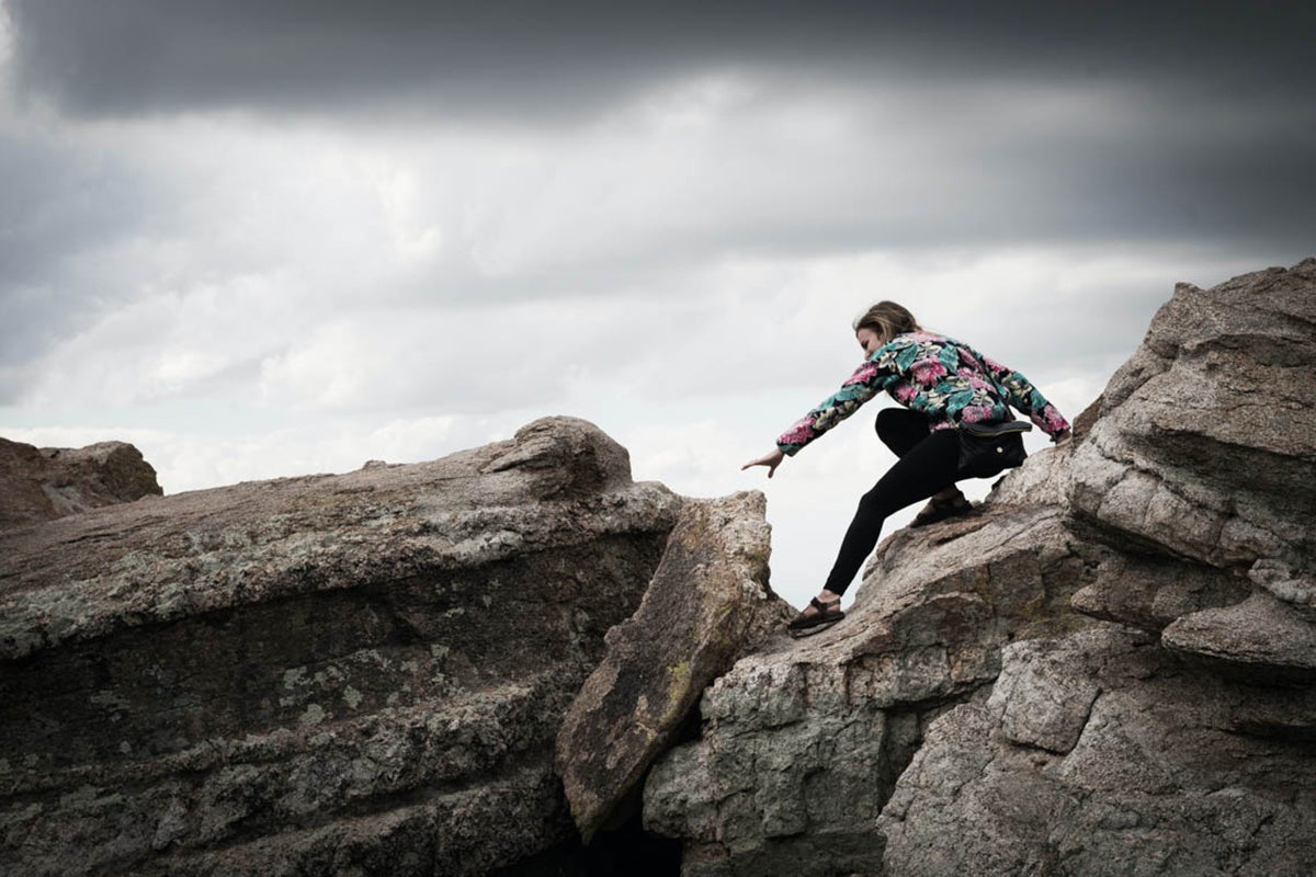 woman rock climbs