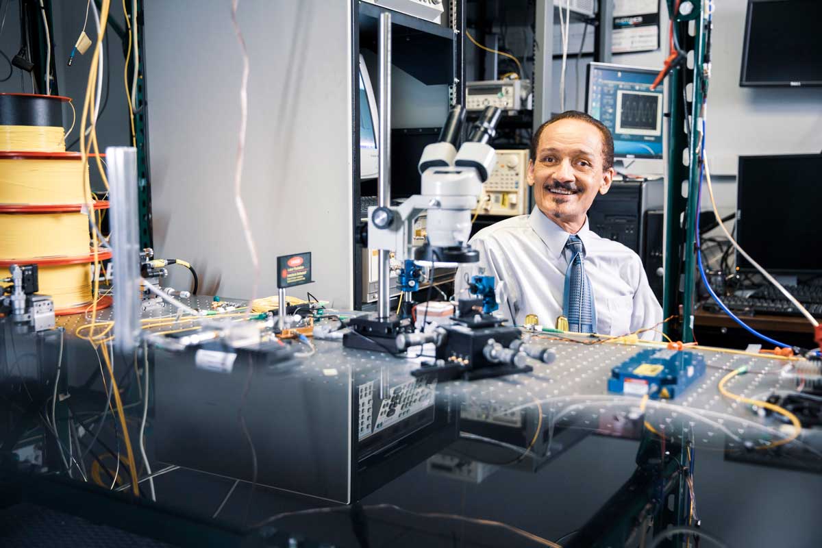 Peter Delfyett in a lab surrounded by computer and technical equipment