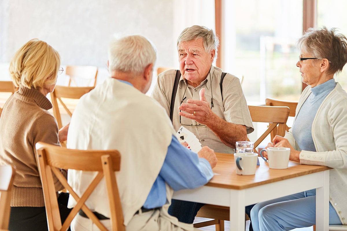 Older adults sitting at a table and talking