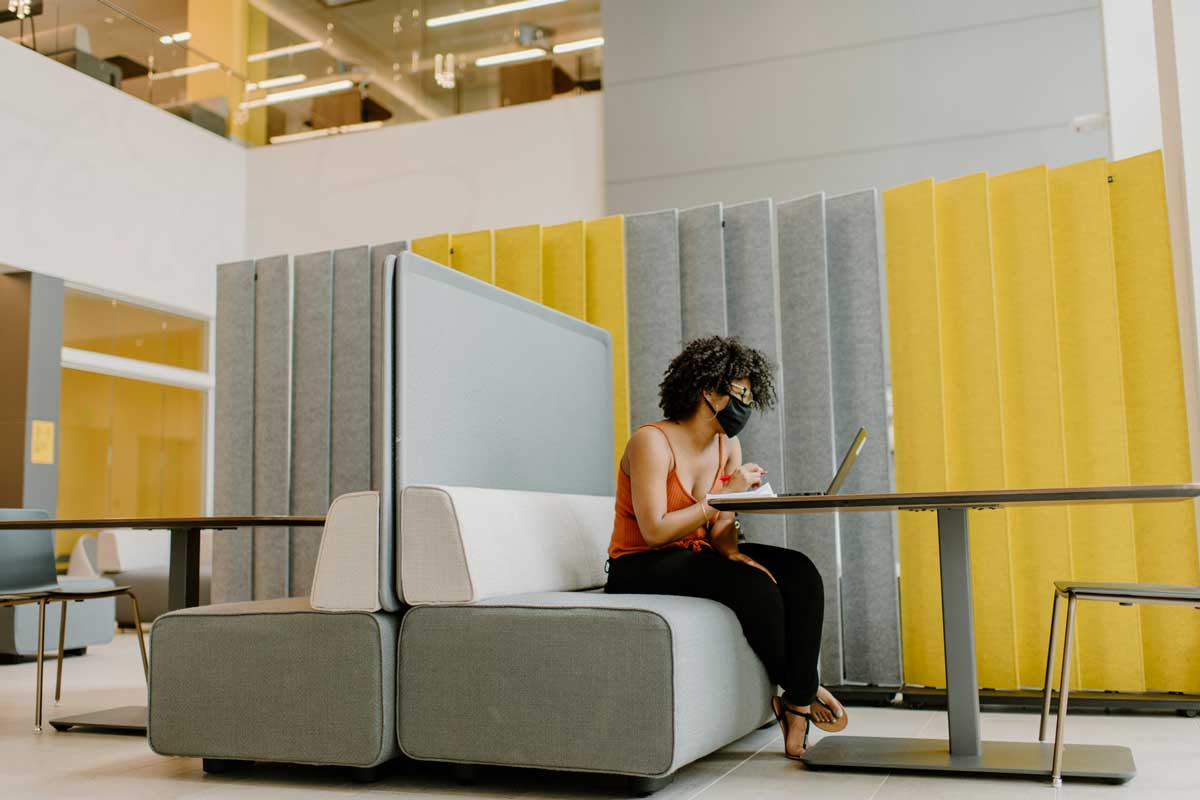 Woman sits at a table with her laptop