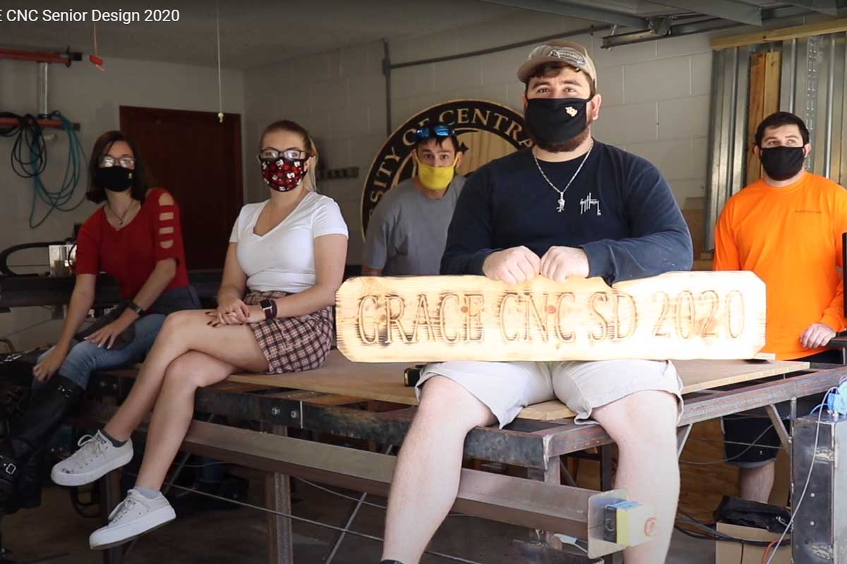Zoom snapshot of 5 engineering students wearing masks in a workspace