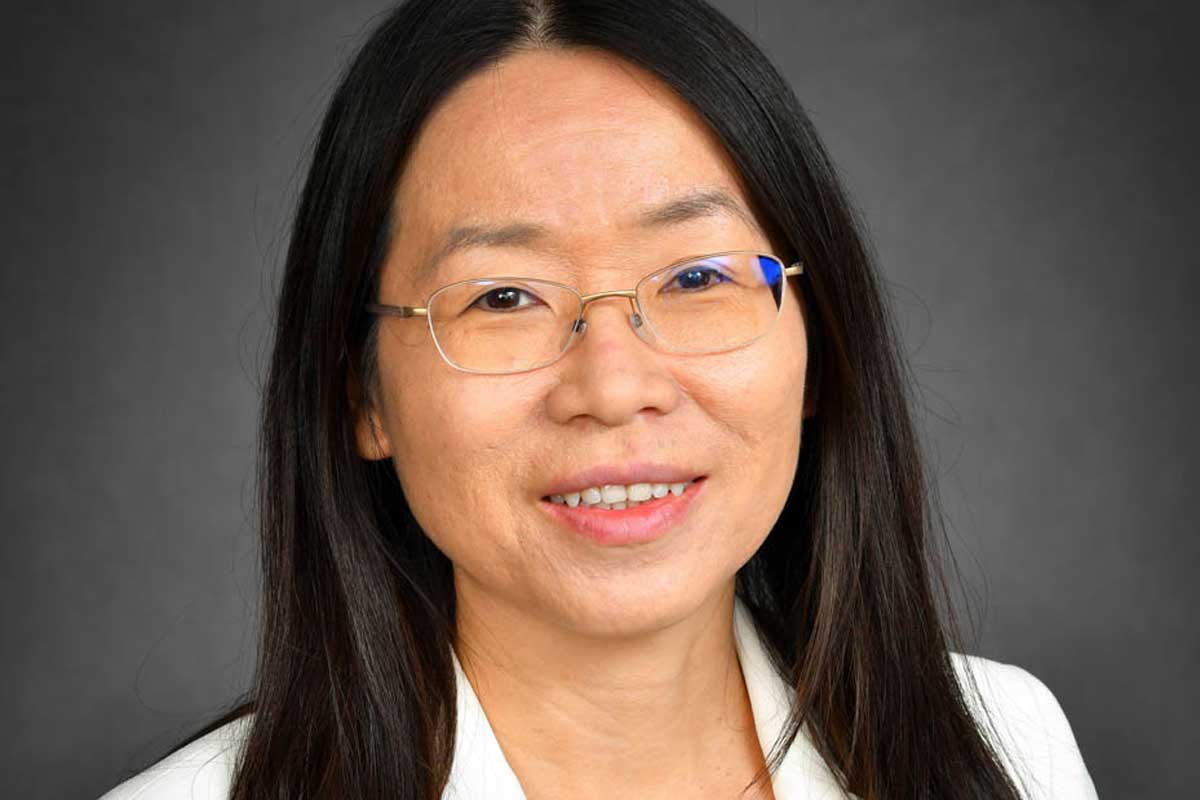 Headshot of Asian woman with glasses and white blazer