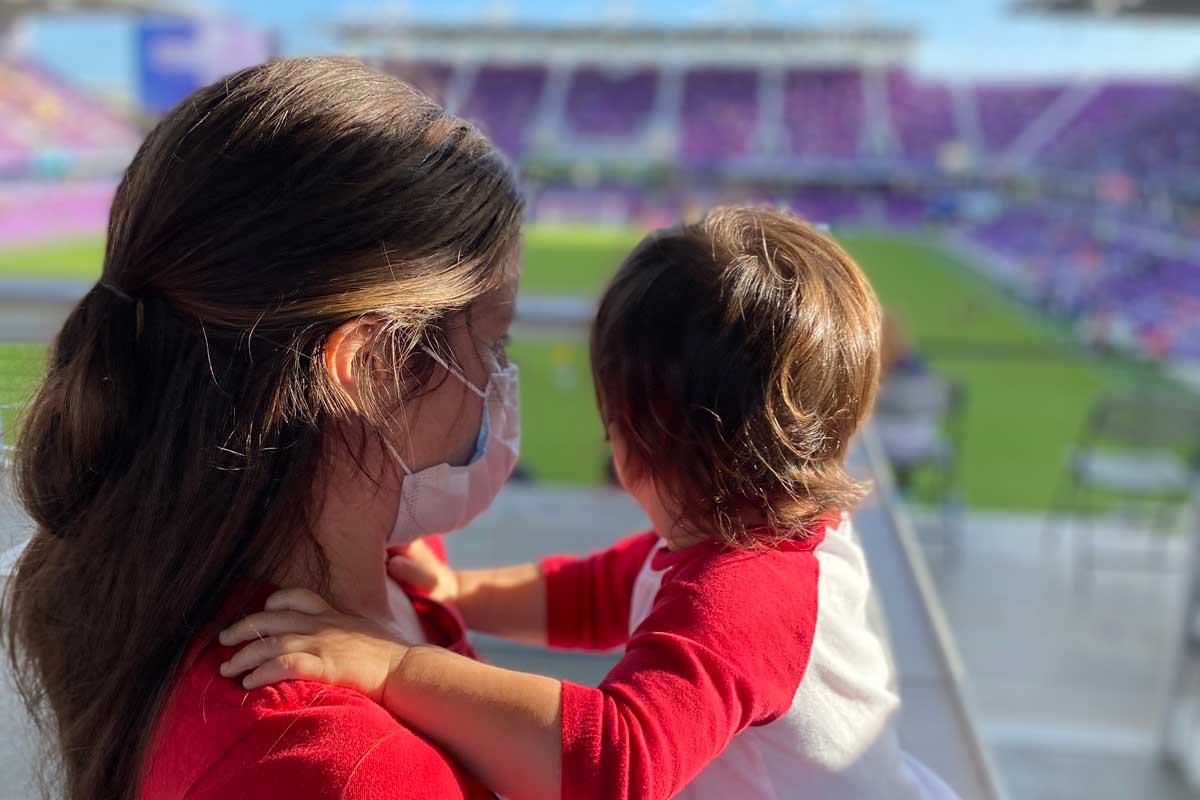 Profile shot of a mother holding her toddler son at a stadium