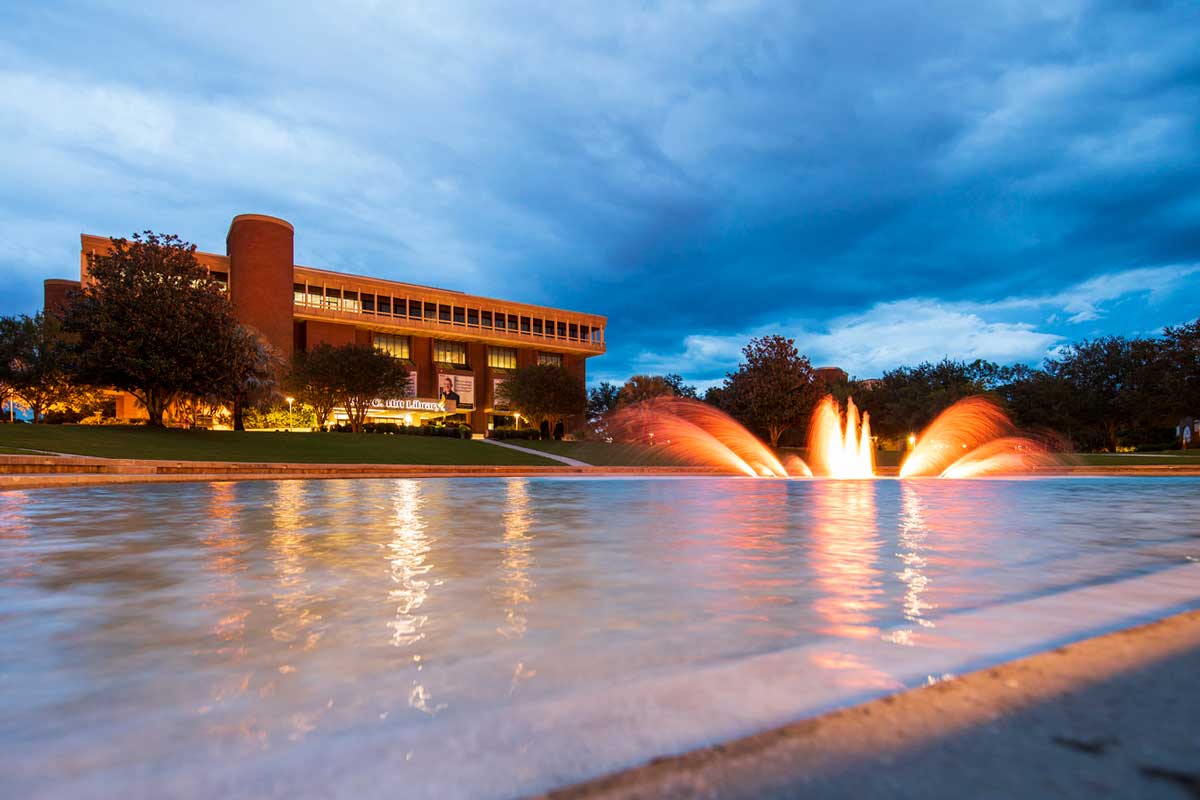 reflecting pond with fountain feature lit in orange