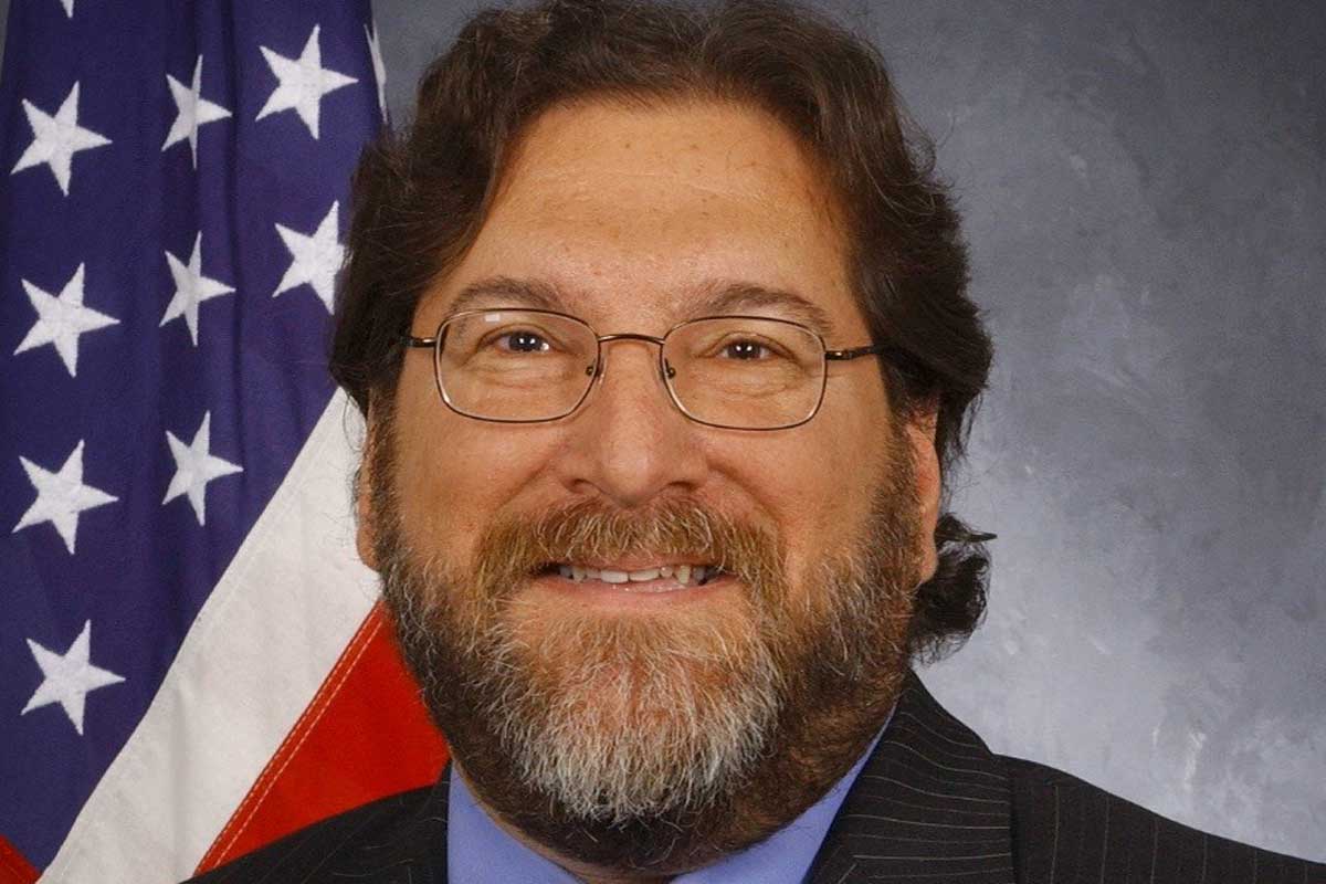 headshot of David Kotick with American flag in background