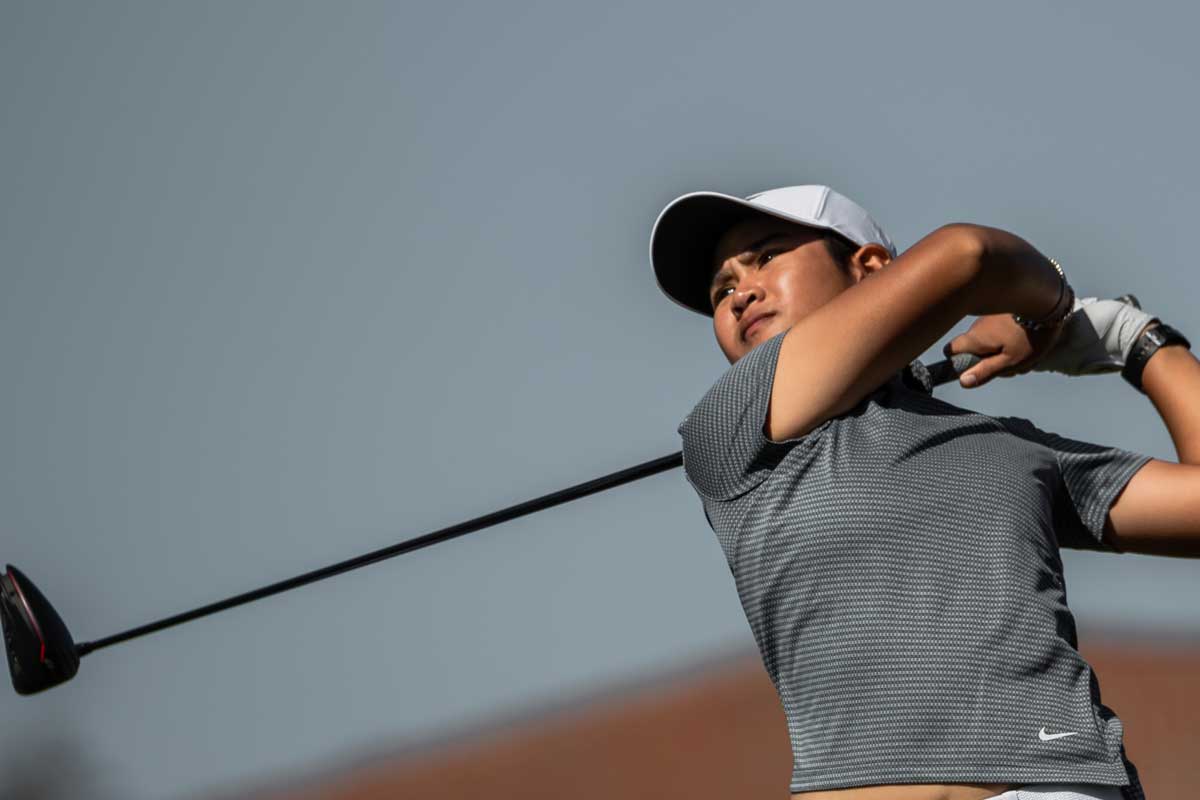 Women's golf player holds club after swing