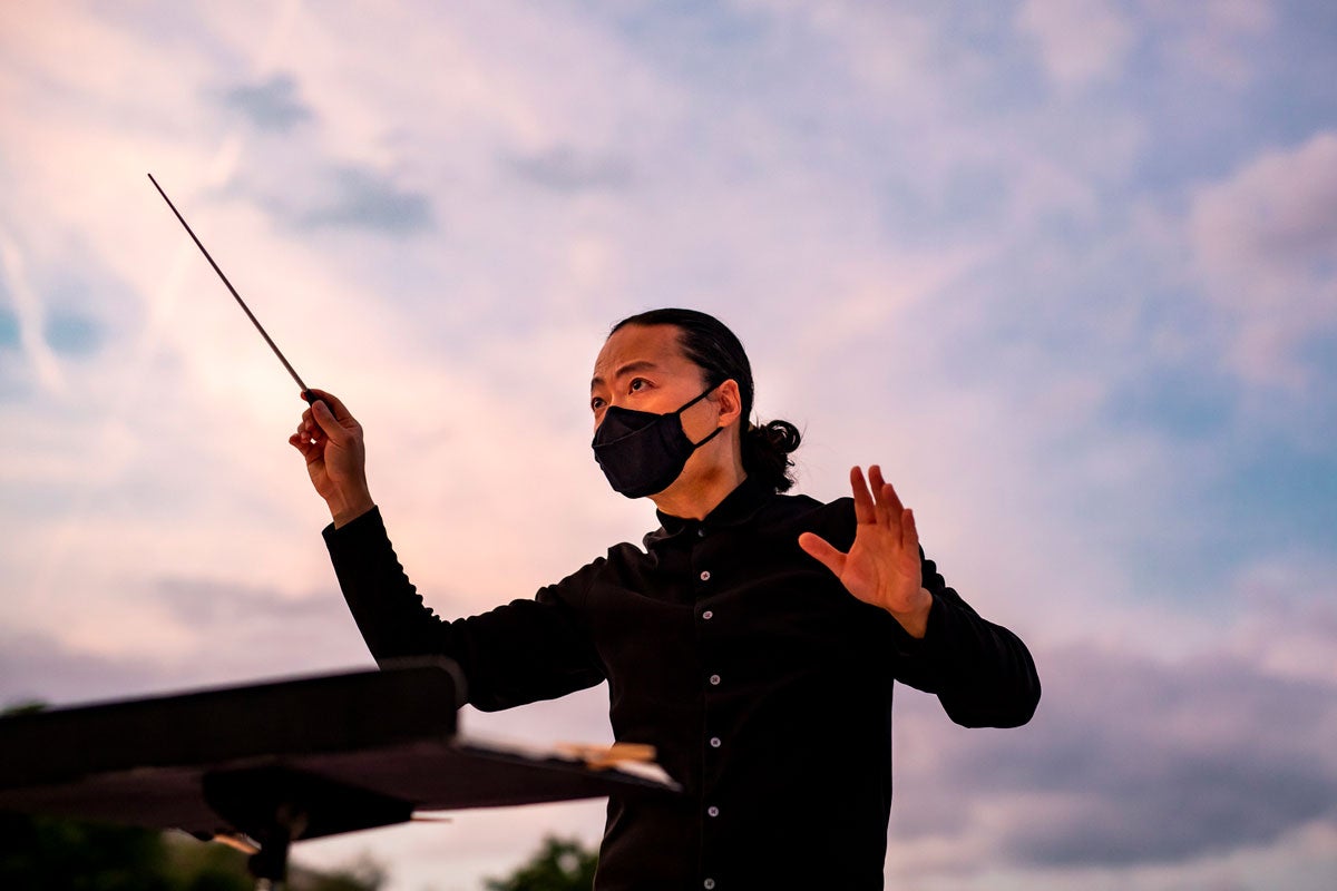 Chung Park conducts orchestra during sunset