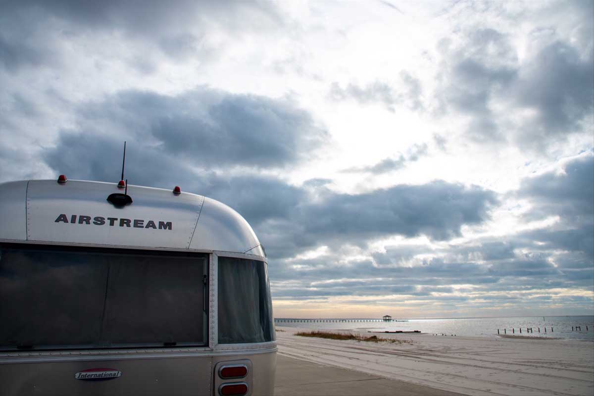 Airstream parked near coastline on a cloudy day