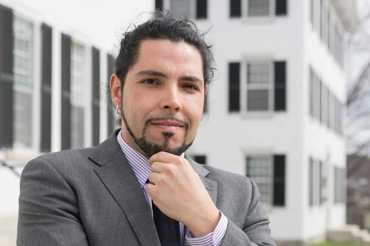 Man in business suit holds hand up to his chin