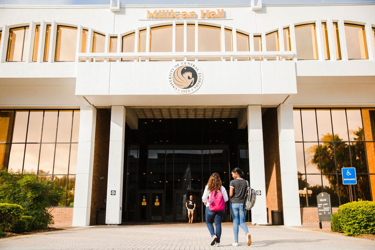 2 students walk outside Millican Hall