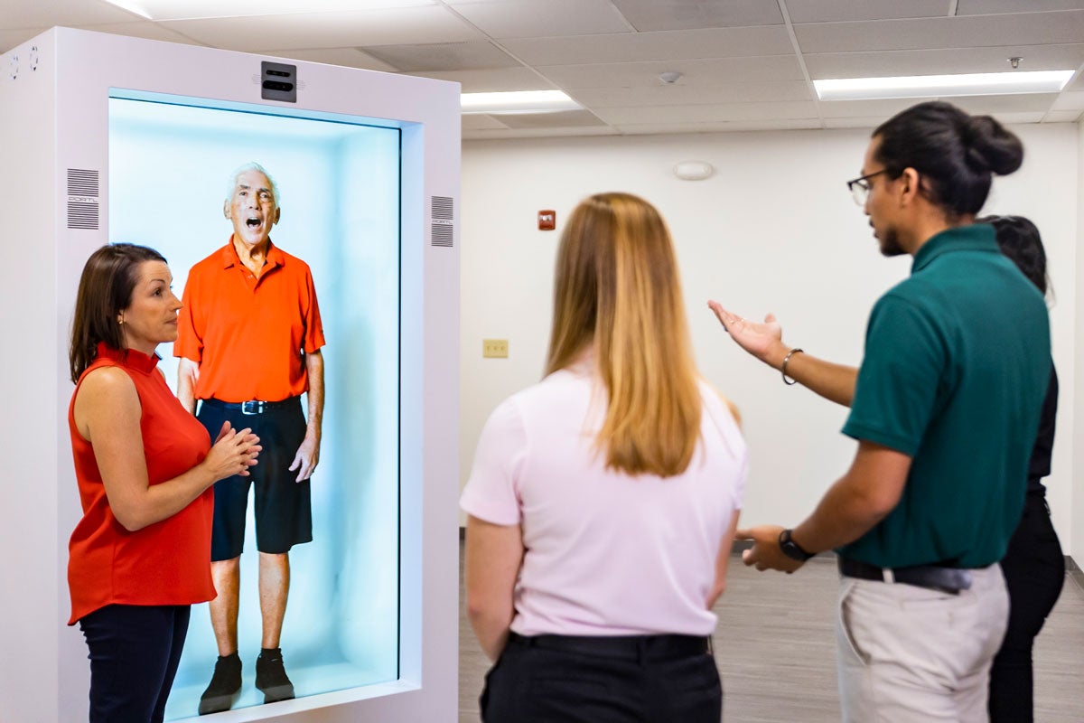 Professor instructs students who observe hologram technology