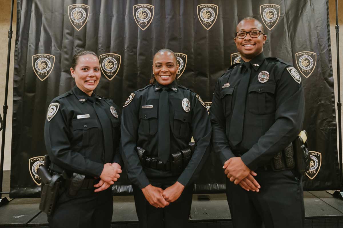 Three officers stand shoulder to shoulder