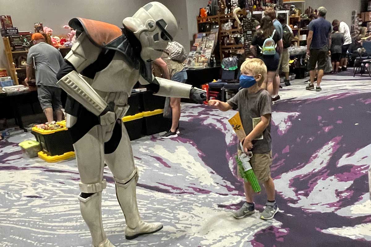 Sandtrooper fist bumps with a young blonde child
