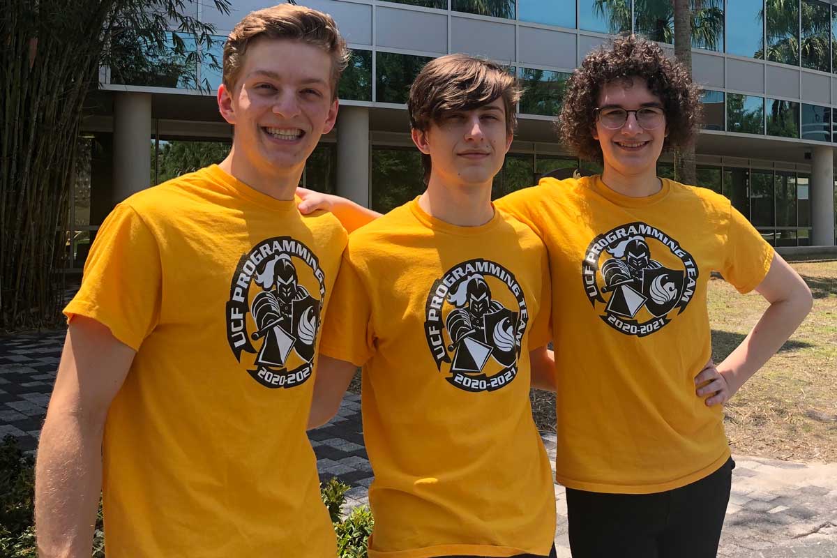 three members of UCF programming team wearing matching gold shirts