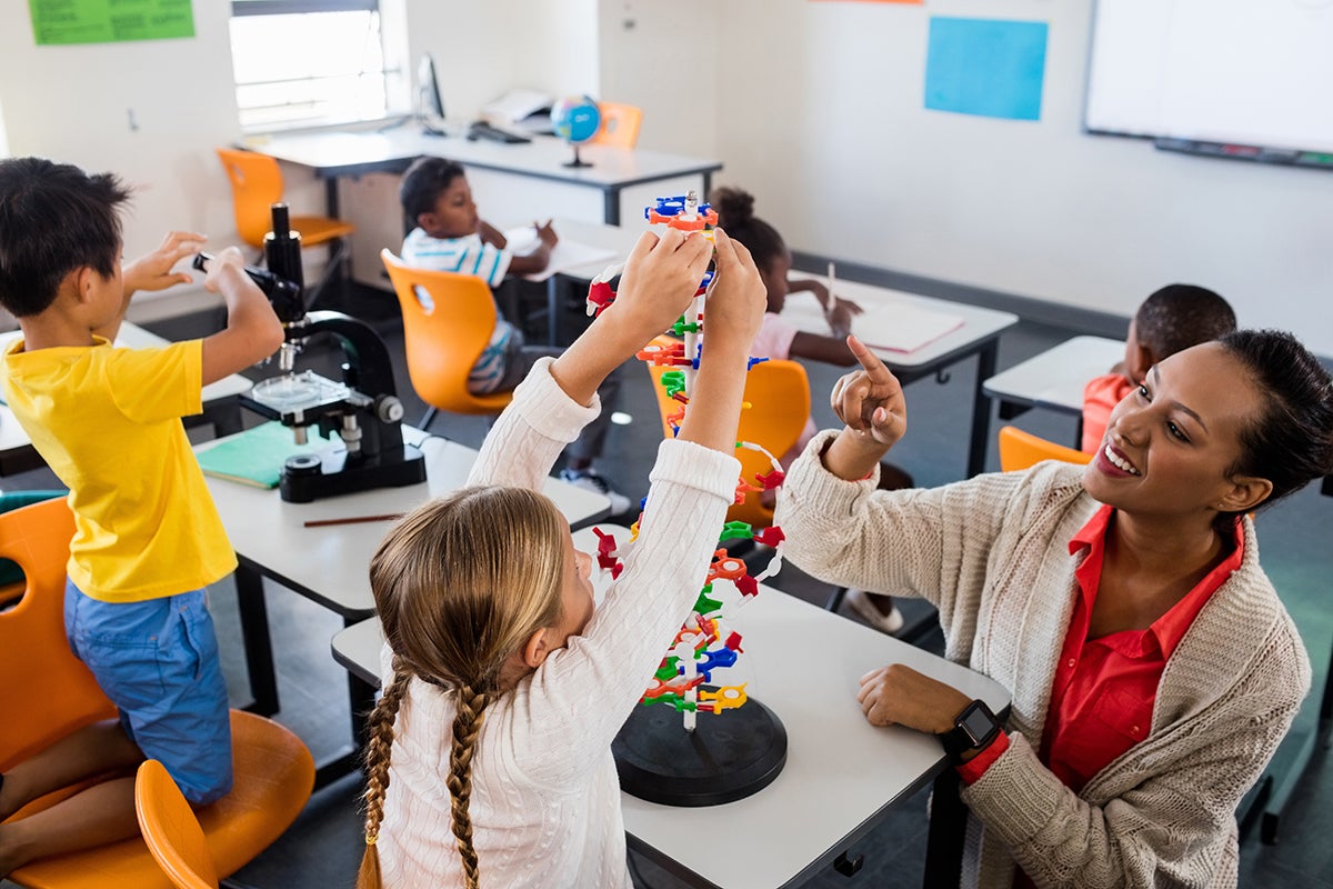 children working in a classroom with a teacher