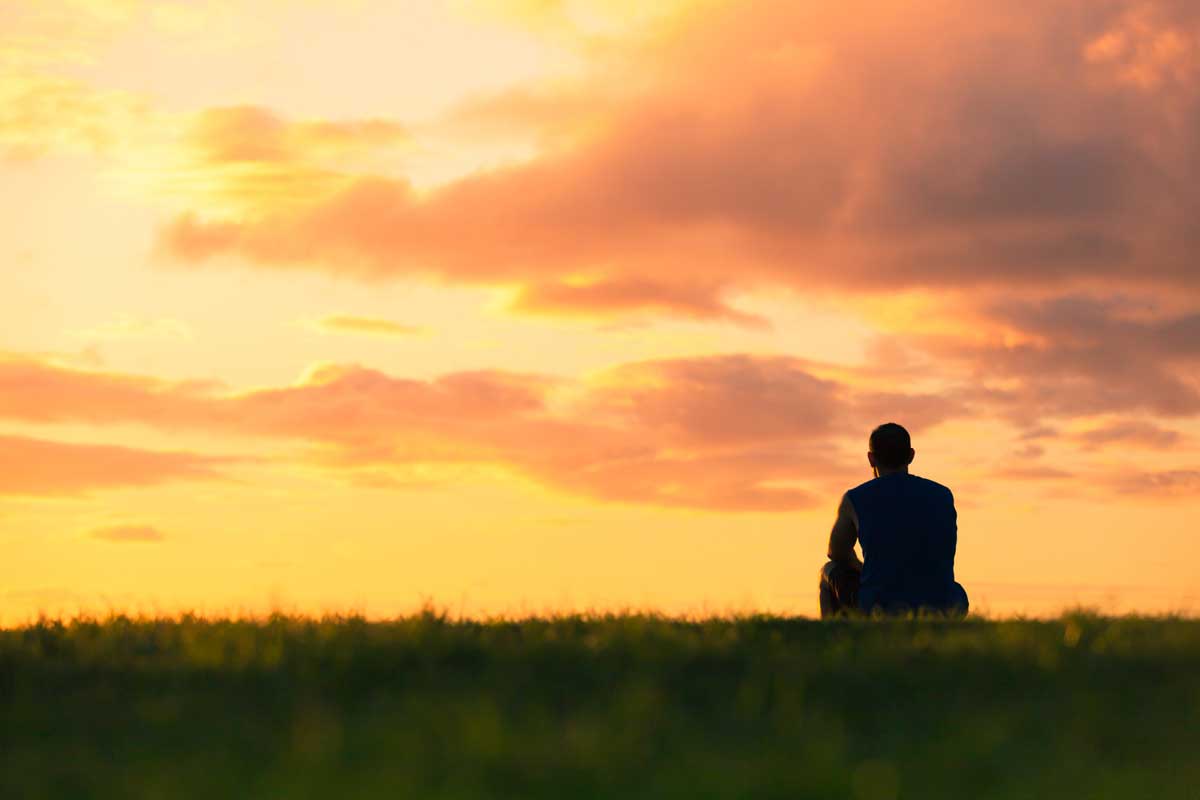 Man sitting watching sunset