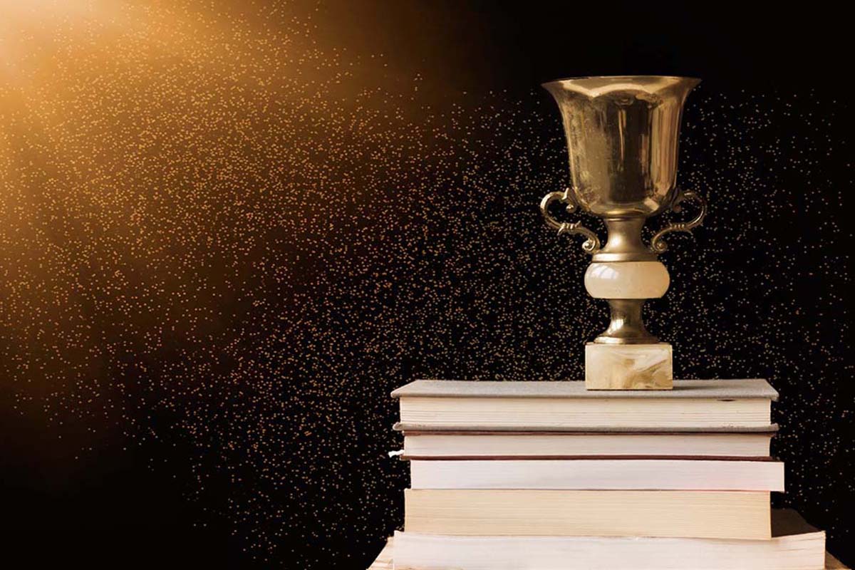 a trophy sits on top of a stack of books