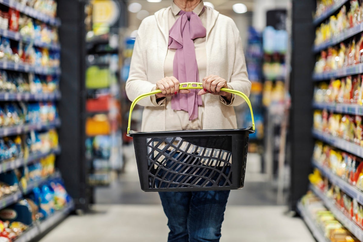 Cropped picture of a senior woman holding empty shopping basket during economy crises.