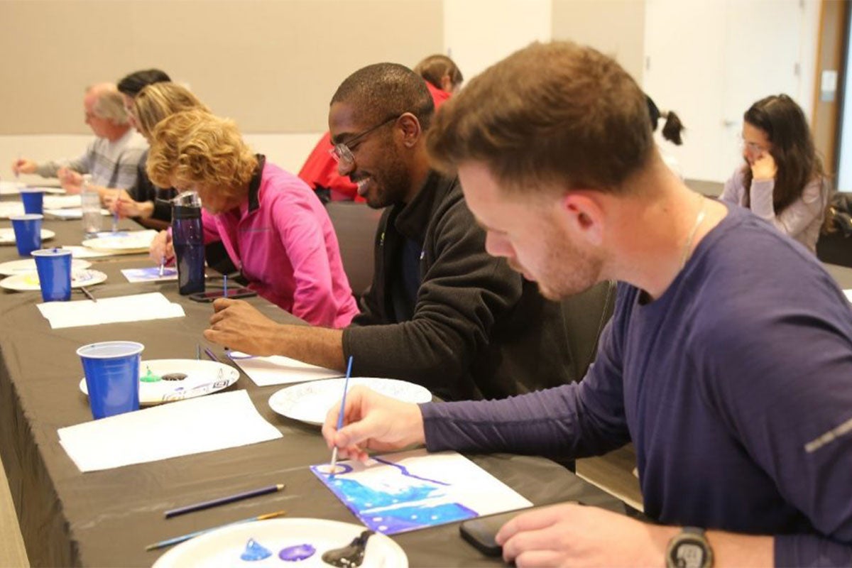 People sitting at a table and painting