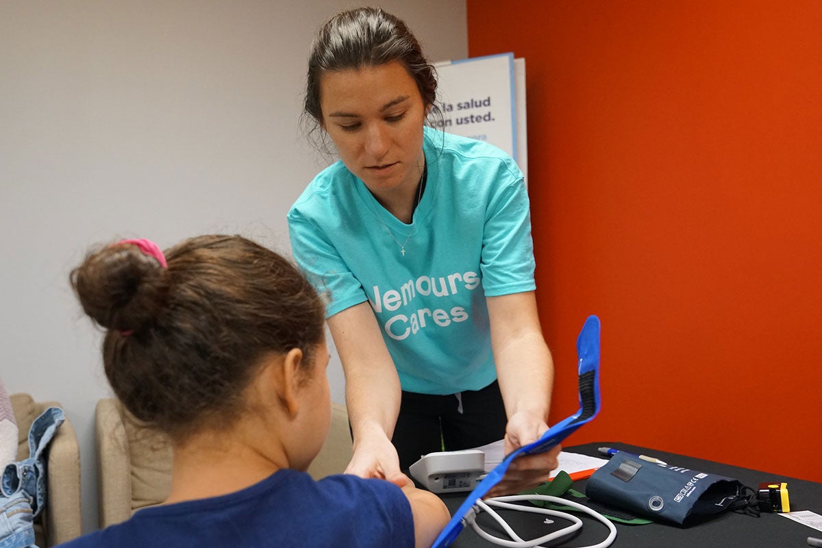 Medical student Carolyn Rapp takes a patient’s blood pressure at Nemours Children’s Health mobile clinic.