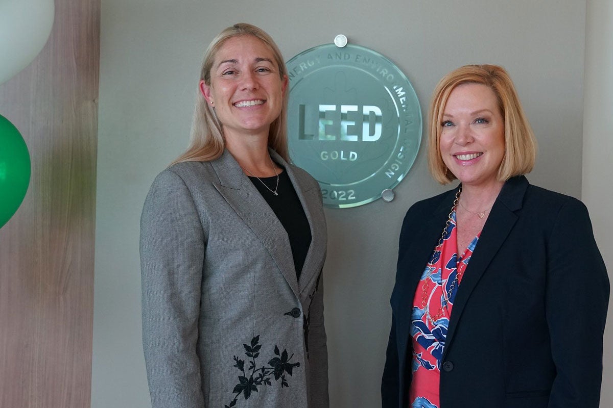 Wendy bandon and Amy Pastor in front of the LEED Gold emblem on the UCF Lake Nona Medical Center