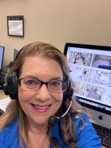 Nadine Jacobsen takes a selfie near a computer 